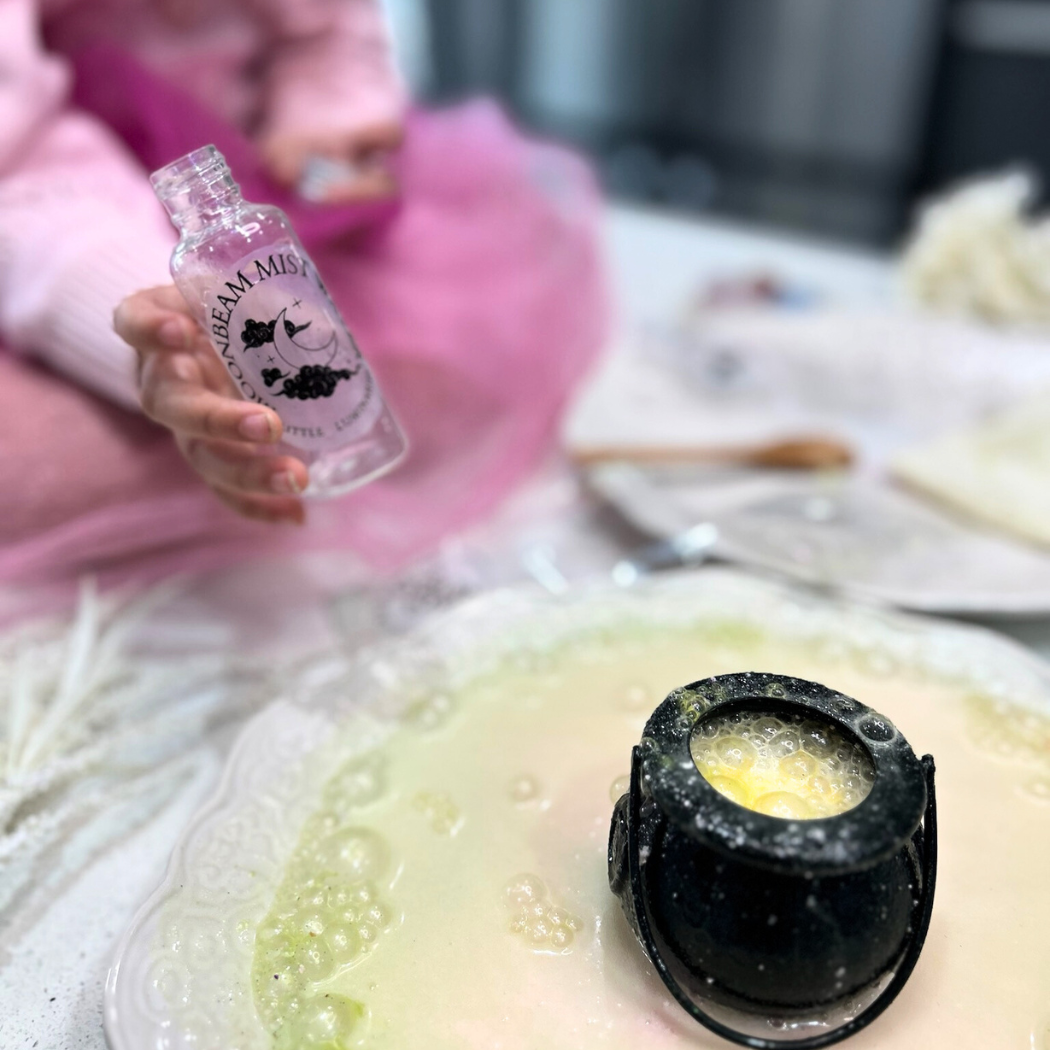 Person holding a bottle labeled 'Cream Mist' over a dish with a black container on top.