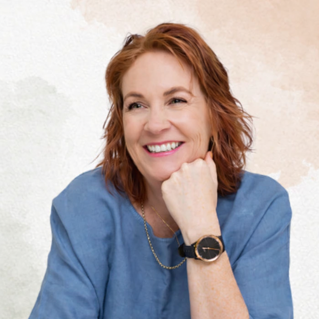Woman wearing a blue shirt and black watch with a neutral background