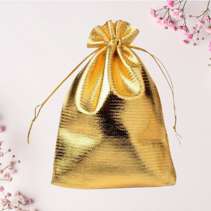Gold drawstring pouch on a light pink background with floral elements