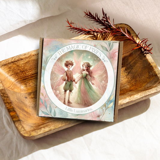 Card with fairy design on a wooden surface with feathers