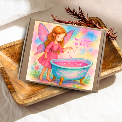 Box labeled 'The Sparkle Bath Box' with a fairy illustration on a wooden surface.