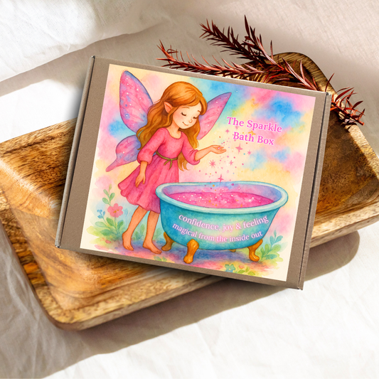 Box labeled 'The Sparkle Bath Box' with a fairy illustration on a wooden surface.